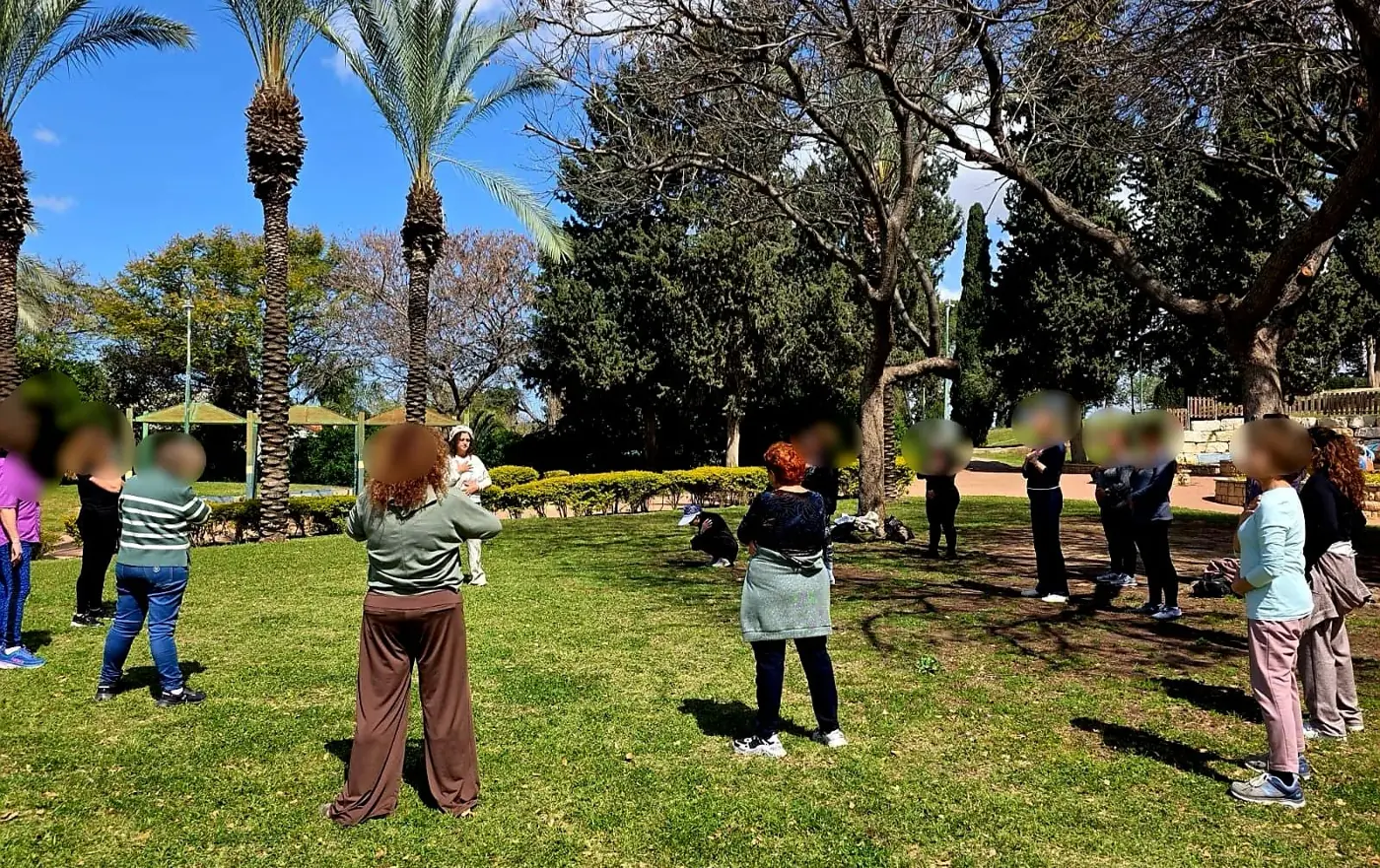 קבוצת נשים בתנועה על הדשא בפארק